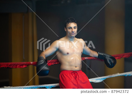 Sad exhausted shirtless boxer in ring 87942372