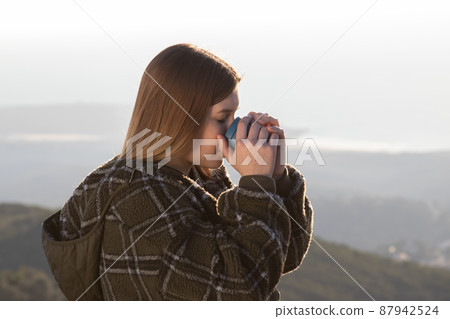 Portrait of teenage girl wearing sweatshirt drinking tea 87942524