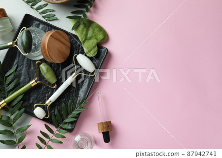 Skin care beauty concept with face rollers on pink background 87942741