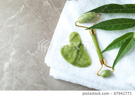 Skin care concept with face roller on gray textured table 87942771