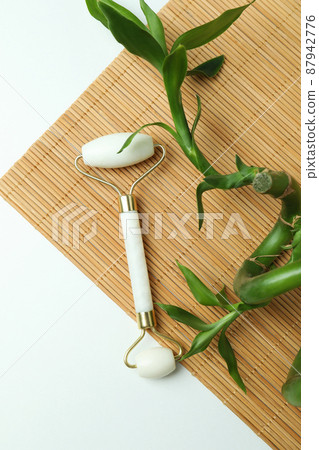 Skin care concept with face roller on white background Skin care concept with face roller on white background 87942776