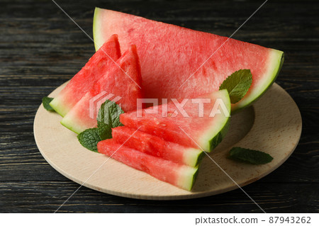 Wooden board with watermelon slices and mint leaves 87943262