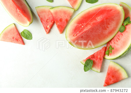 Watermelon slices and mint leaves on white textured table Watermelon slices and mint leaves on white textured table 87943272