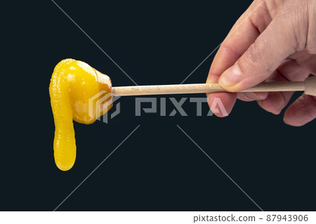 Fresh viscous flower honey falls down from a wooden spoon. vitamin organic food Fresh viscous flower honey falls down from a wooden spoon. vitamin organic food 87943906
