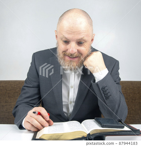 happy bearded man studies the Bible. religion and Christianity. 87944183