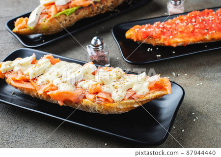 Traditional Spanish breakfast. Tostada with different toppings on a dark background 87944440