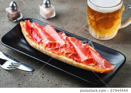 Traditional Spanish breakfast. Tostada with different toppings on a dark background Traditional Spanish breakfast. Tostada with different toppings on a dark background 87944444