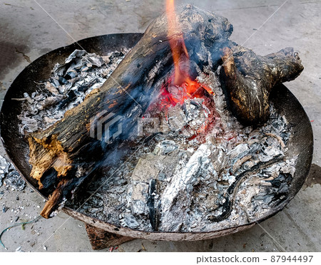 Logs burn in the campfire. Close-up of firewood, coals Logs burn in the campfire. Close-up of firewood, coals 87944497