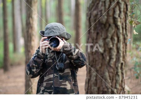 Happy boy with camera in forest Happy boy with camera in forest 87945231