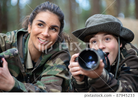 Happy family taking pictures in forest Happy family taking pictures in forest 87945233