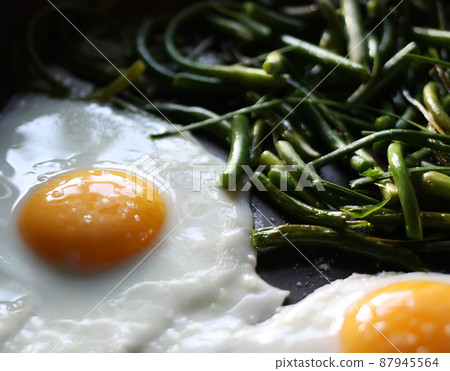 Fried eggs with green beans 87945564