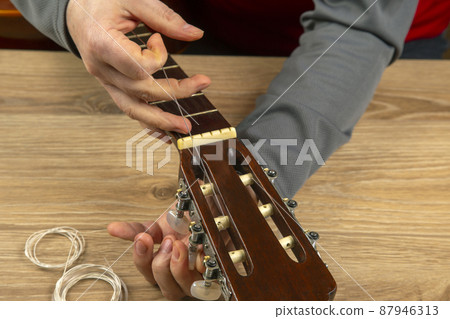 Changing nylon strings on a six-string classical guitar. instruction for musician Changing nylon strings on a six-string classical guitar. instruction for musician 87946313