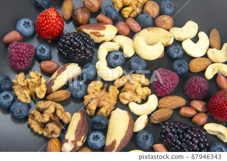 different berries and nuts on a plate. vitamin proteins and healthy foods different berries and nuts on a plate. vitamin proteins and healthy foods 87946343