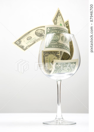dollar banknotes money lies in an empty wine glass. business in the wine industry. alcohol marketing dollar banknotes money lies in an empty wine glass. business in the wine industry. alcohol marketing 87946700