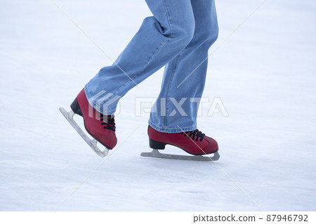 feet on skates on an ice rink. winter sport and recreation 87946792