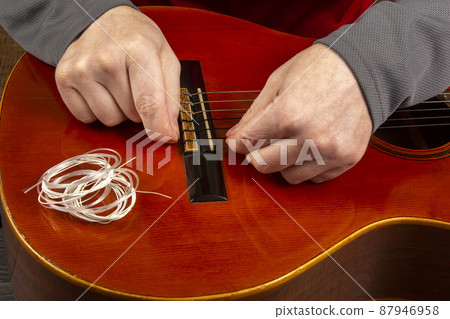 Changing nylon strings on a six-string classical guitar. instruction for musician Changing nylon strings on a six-string classical guitar. instruction for musician 87946958