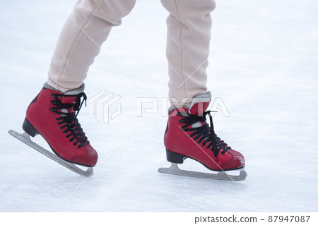 feet on skates on an ice rink. winter sport and recreation 87947087