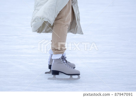 Ice skating on an ice rink. legs with skates. Winter active sport and leisure hobby. Ice skating on an ice rink. legs with skates. Winter active sport and leisure hobby. 87947091