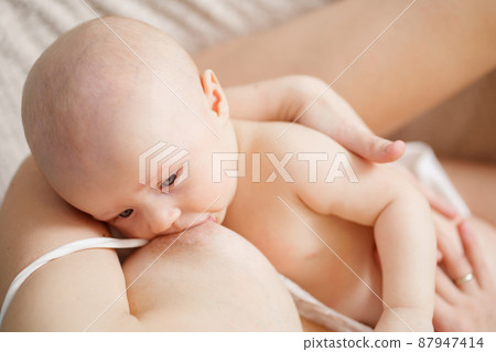top view. kid close-up. a mother feeds baby with breast milk. breastfeeding.  87947414