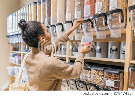Young african american woman buying cereals and grains in sustainable grocery store 87947452