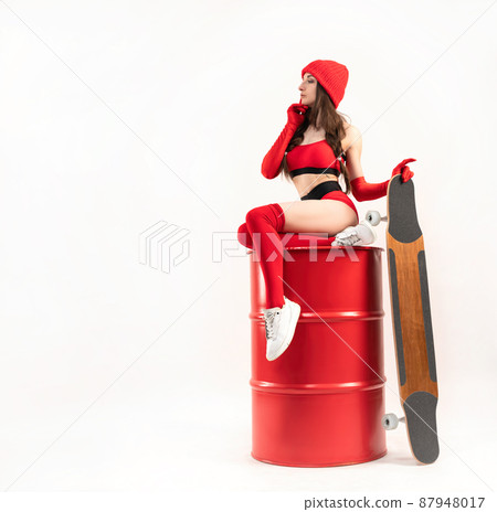 a girl in a red hat with a longboard in short red sports summer clothes on a white background 87948017