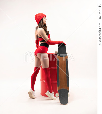 a girl in a red hat with a longboard in short red sports summer clothes on a white background 87948019