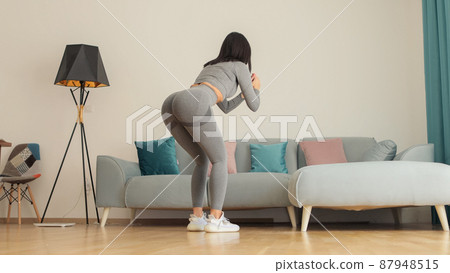 Young sporty woman glutes squats workout morning routine. home fitness 87948515