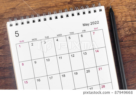 May 2022 desk calendar with wooden pencil on wooden table. 87949668