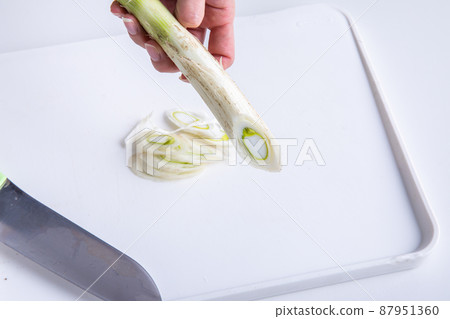 Leek at hand to cut long onions 87951360