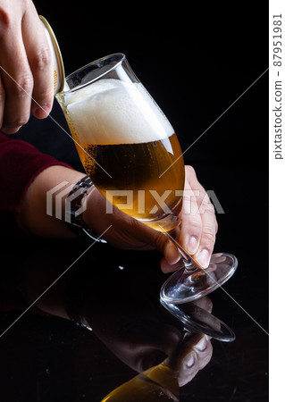 拿著啤酒杯的男人手邊的啤酒 拿著啤酒杯的男人手邊的啤酒 87951981