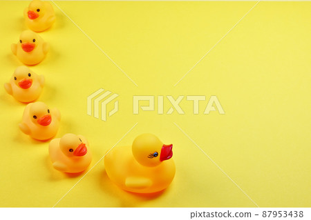 Line up toy ducks on a yellow background 87953438
