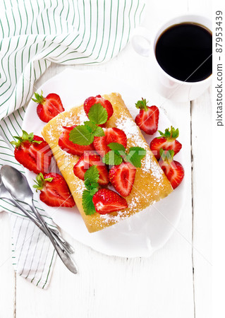 Roll with cream and strawberries in plate on board top Roll with cream and strawberries in plate on board top 87953439