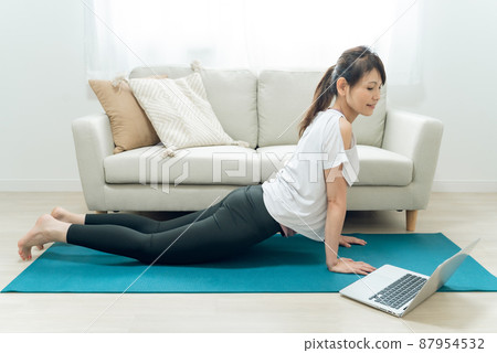 Middle-aged and older women doing online yoga (cobra pose) 87954532