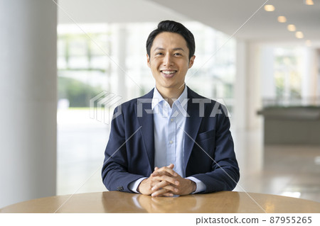 A businessman in his thirties with a smile looking at the camera 87955265