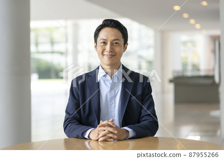 A businessman in his thirties smiling looking at the camera A businessman in his thirties smiling looking at the camera 87955266