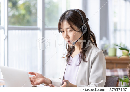 A business woman who works indoors with a headset on 87957167