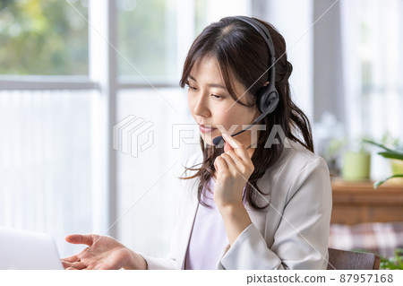A business woman who works indoors with a headset on 87957168