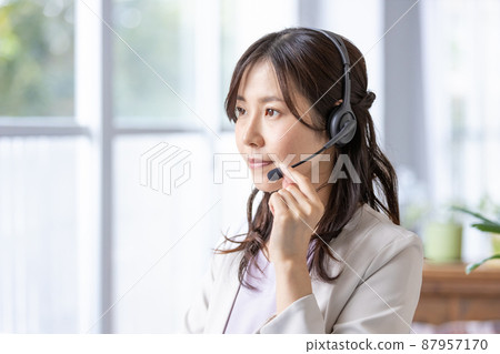 一位戴著耳機在室內工作的女商人 87957170
