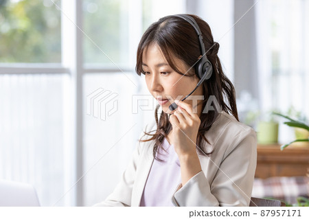 一位戴著耳機在室內工作的女商人 87957171