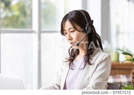 一位戴著耳機在室內工作的女商人 87957172