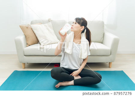 Middle-aged women doing yoga in the room (drinking protein) Middle-aged women doing yoga in the room (drinking protein) 87957276