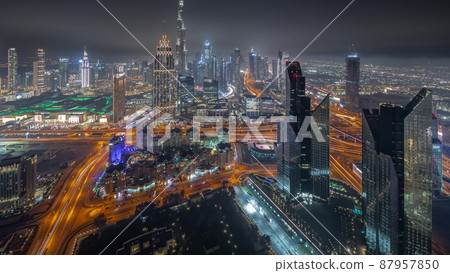 Aerial view of tallest towers in Dubai Downtown skyline and highway night timelapse. Aerial view of tallest towers in Dubai Downtown skyline and highway night timelapse. 87957850