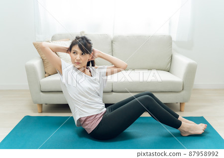 中年婦女(扭動)在房間裡做腹肌 中年婦女(扭動)在房間裡做腹肌 87958992