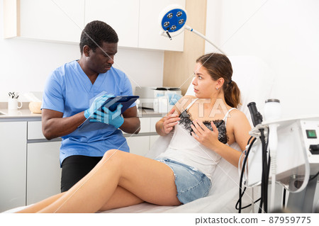 Confident male doctor consult female patient on breast augmentation 87959775