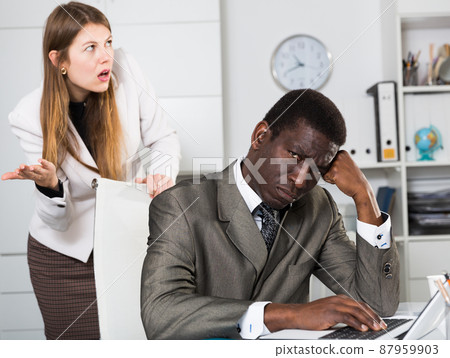 Angry female boss screaming to young male manager during working 87959903