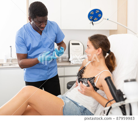 Confident male doctor consult female patient on breast augmentation Confident male doctor consult female patient on breast augmentation 87959983