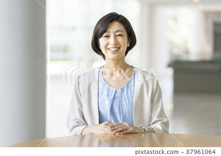 A business woman in her thirties with a smile looking at the camera A business woman in her thirties with a smile looking at the camera 87961064