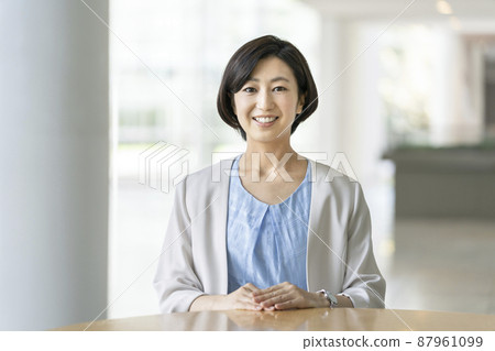 A business woman in her thirties with a smile looking at the camera 87961099