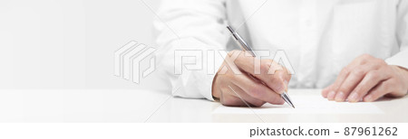 A person writing on paper with a pen 87961262