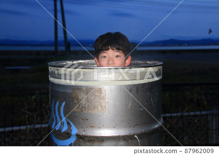 A child enjoying a drum bath in his parking lot, refraining from going out due to the corona 87962009